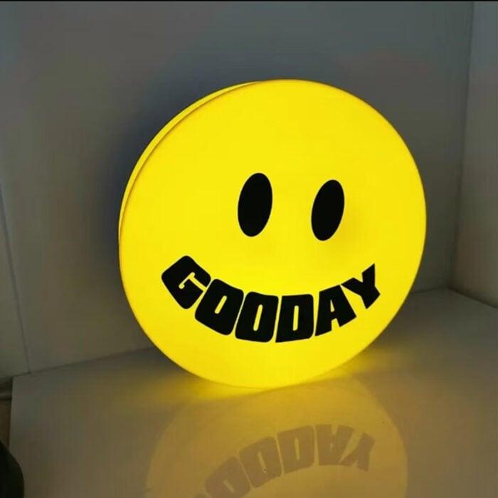 yellow round acrylic light box sign with black text printed
